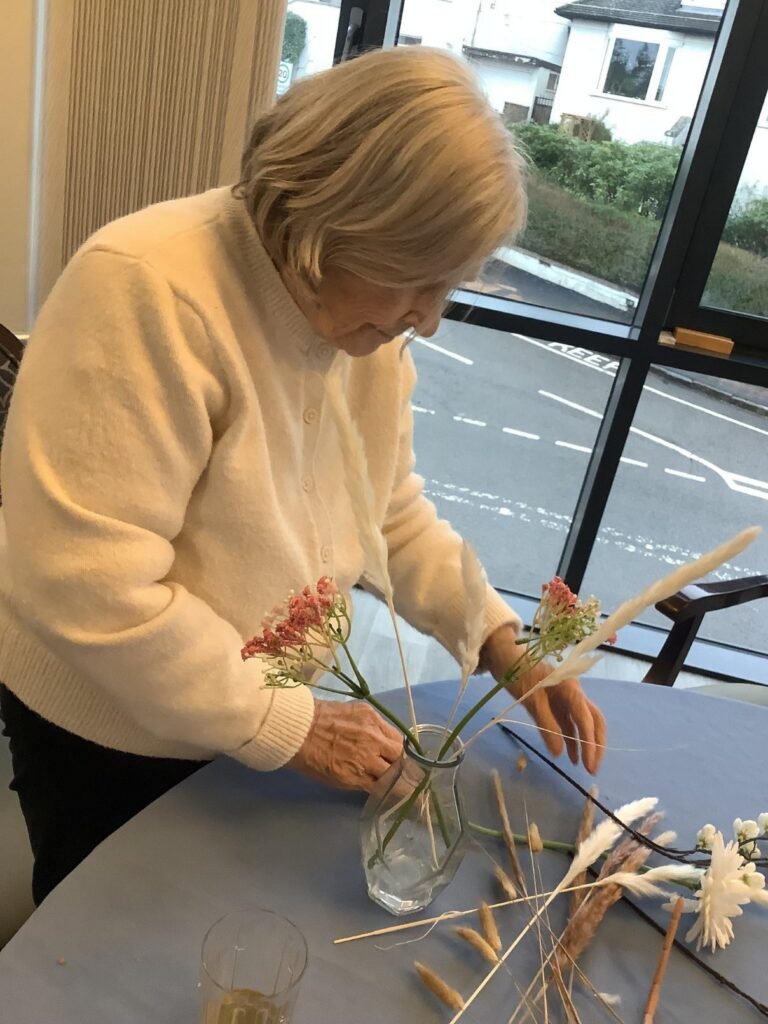 resident arranging flowers in a jar