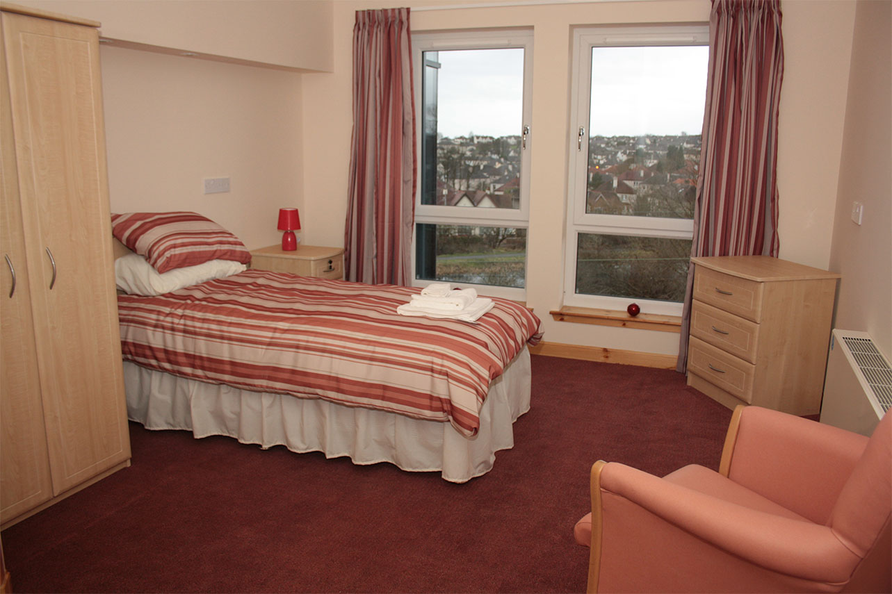 bedroom at westerton care home with red striped textiles
