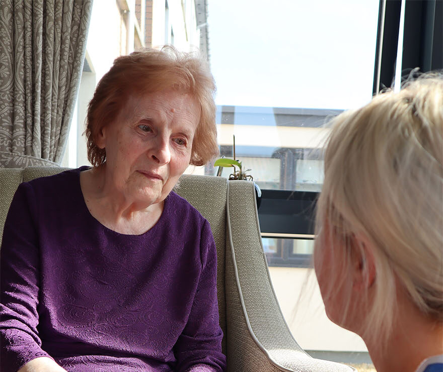 elderly resident holding hands with staff member