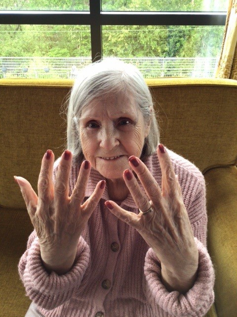 resident showing camera her pink painted nails