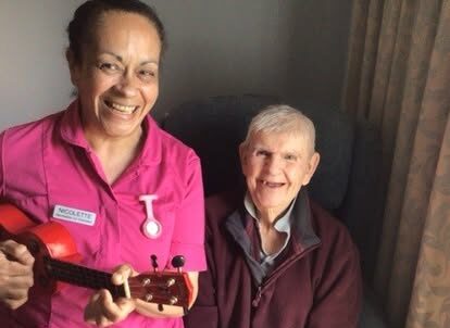 nurse playing a instrument with a resident