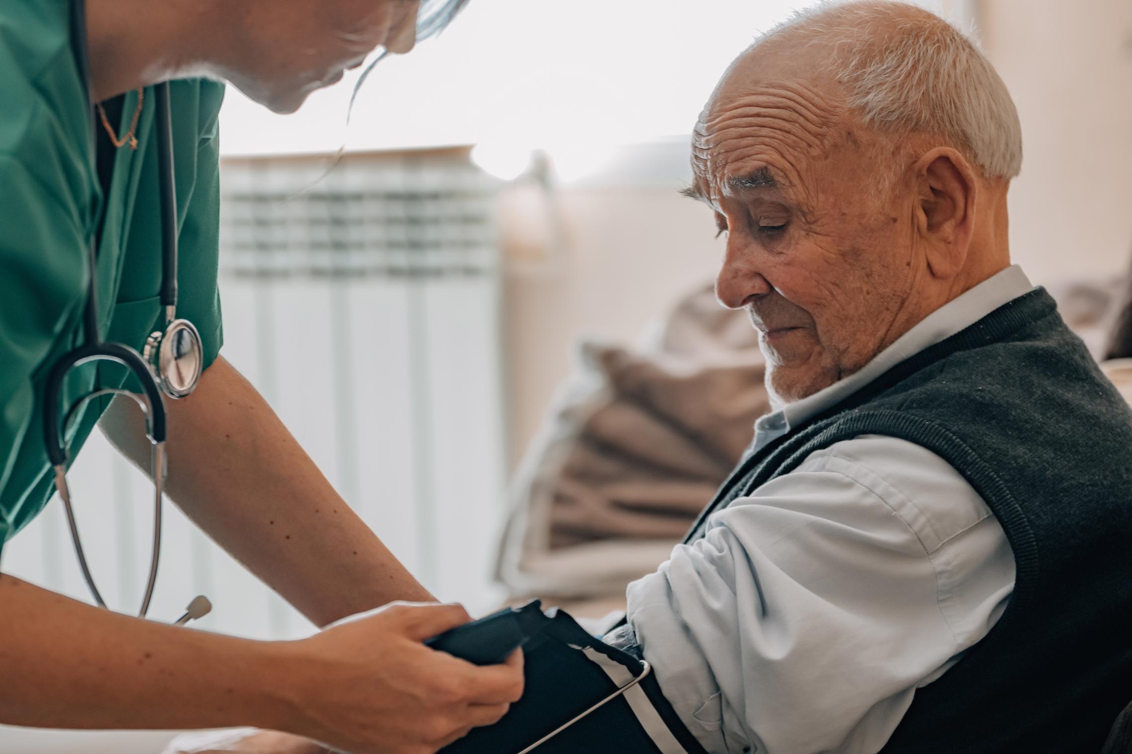 care home nurse taking residents blood pressure
