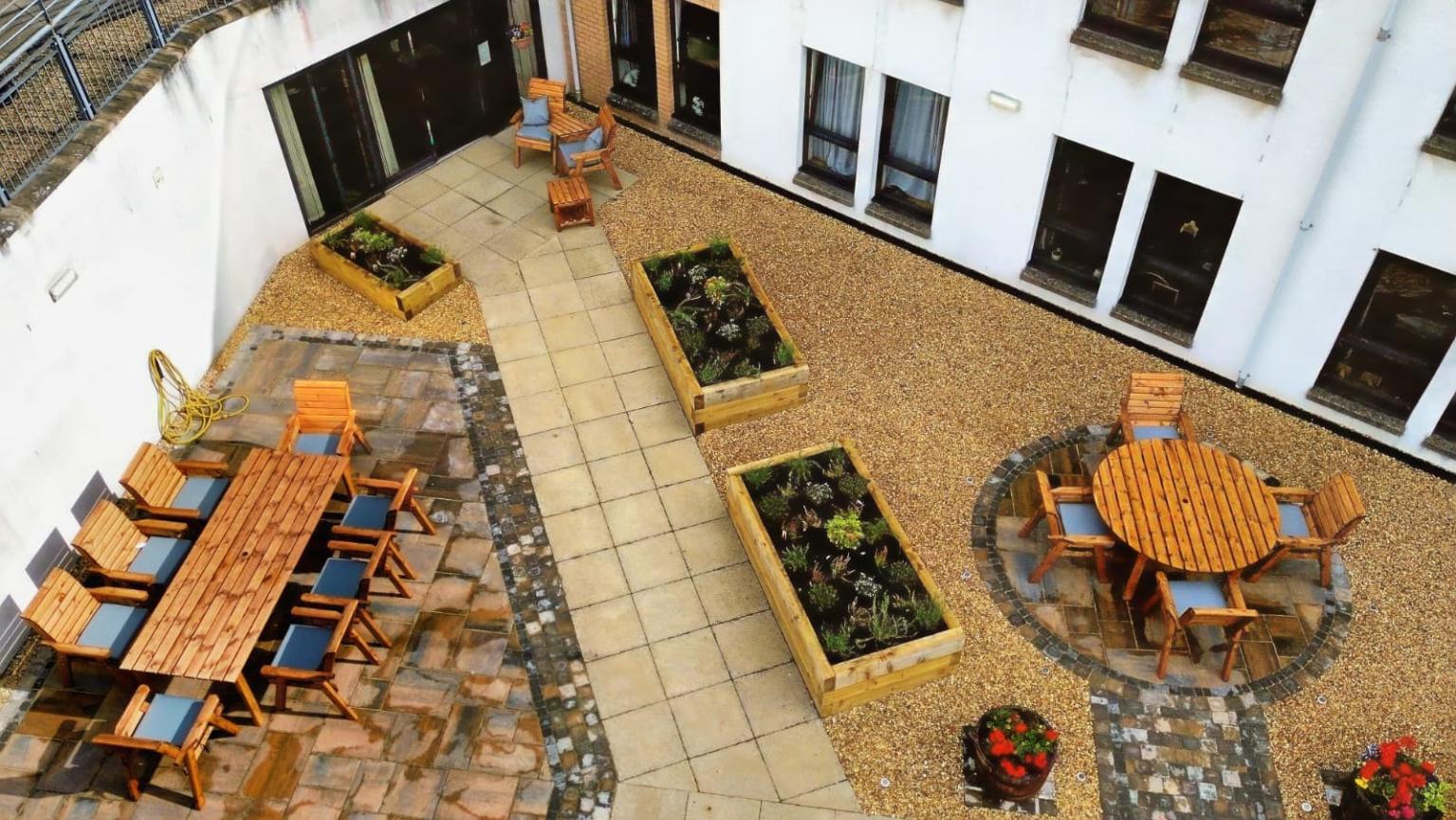 landscaped patio from above with benches and planters